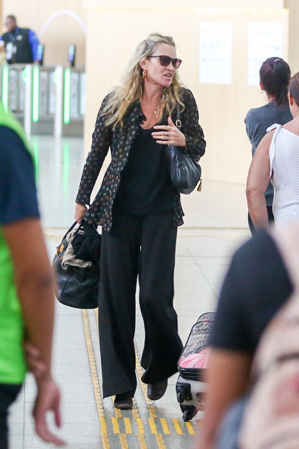 Kate Moss e moreno misterioso embarcam em aeroporto no Rio de Janeiro