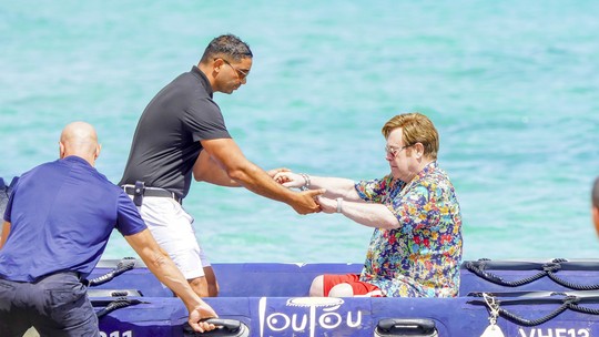Elton John recebe ajuda para sair de bote após passeio de iate com marido e filho; veja fotos