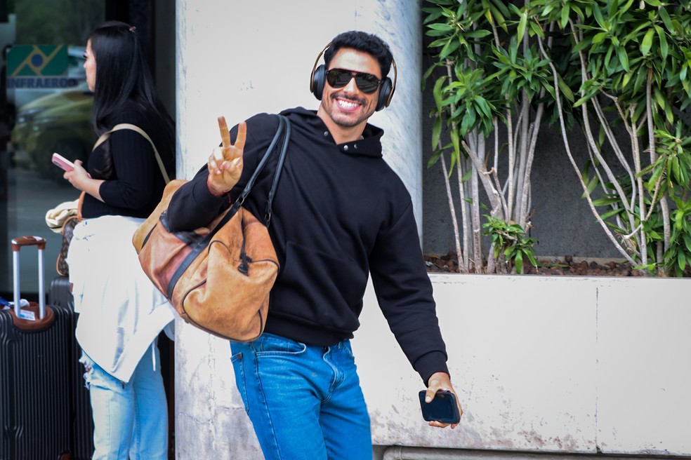 Cauã Reymond tira selfies com fãs no desembarque em clima descontraído