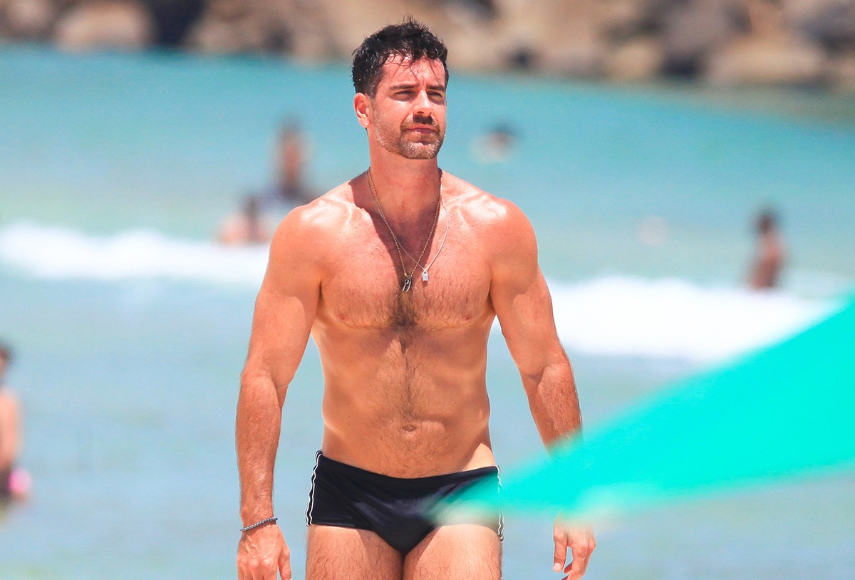 De sunga preta, Marcos Pitombo se refresca em praia no Rio de Janeiro