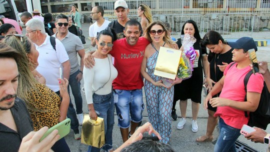 É o Tchan! ganha presentes de fãs em aeroporto do Rio após retorno aos palcos