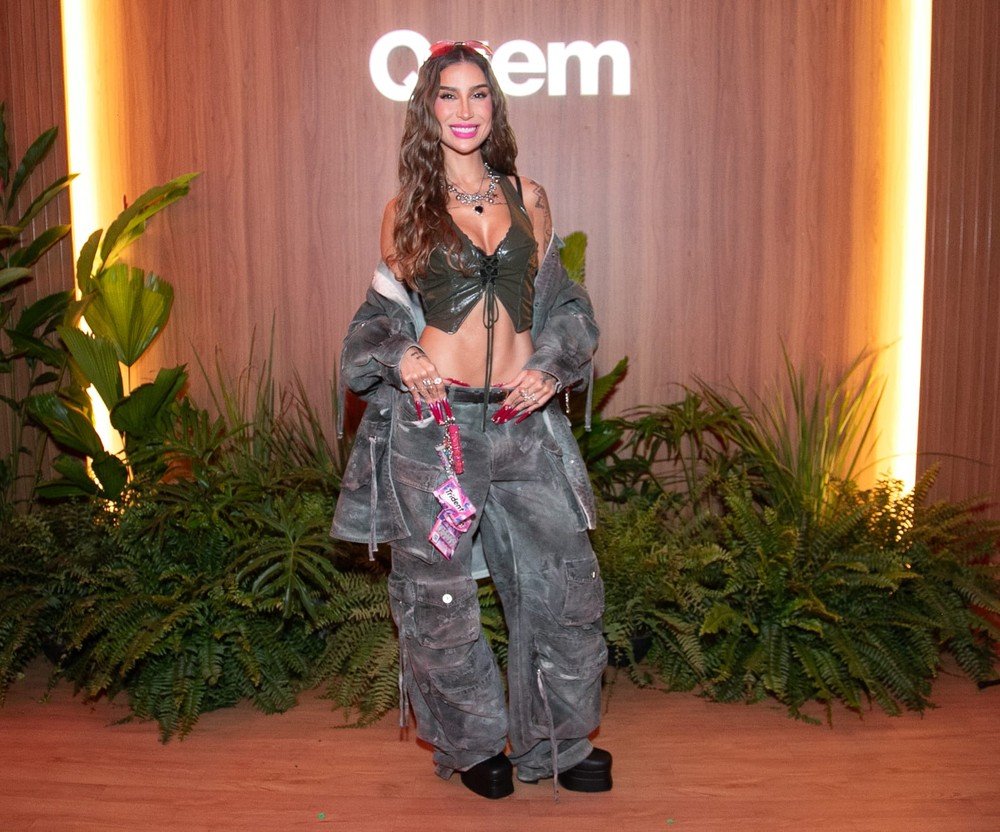 Bianca Andrade na área de valorização do Rock in Rio, vestindo roupa de performance, com a plateia ao fundo e o palco iluminado.