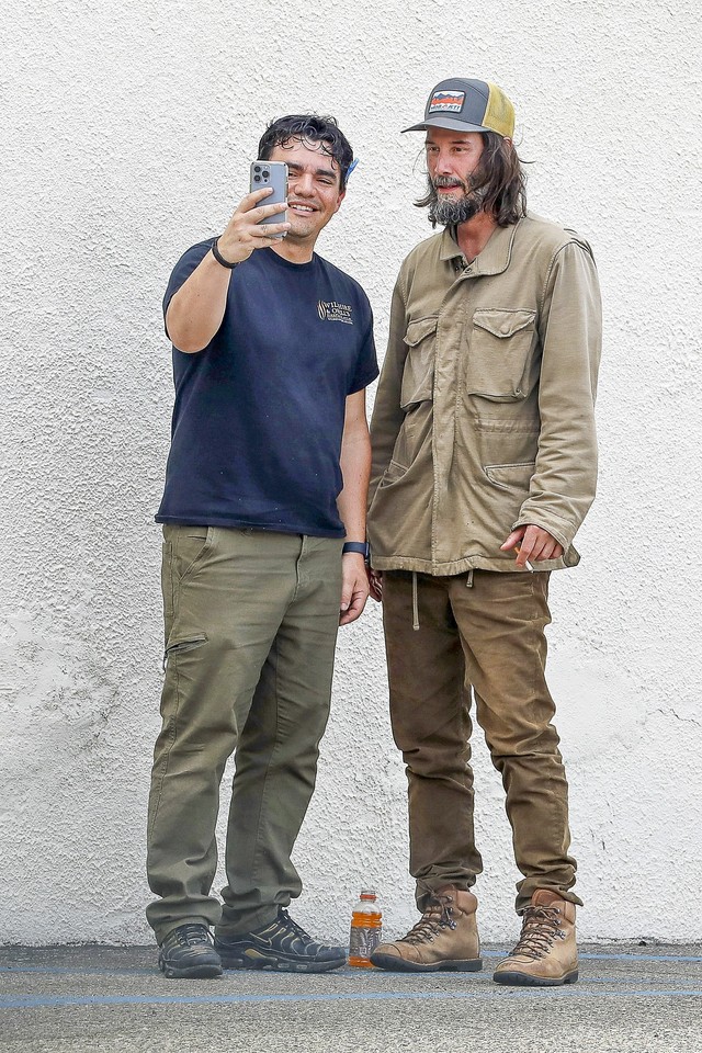 Sentado na calçada, Keanu Reeves é interrompido em momento relaxante e ...