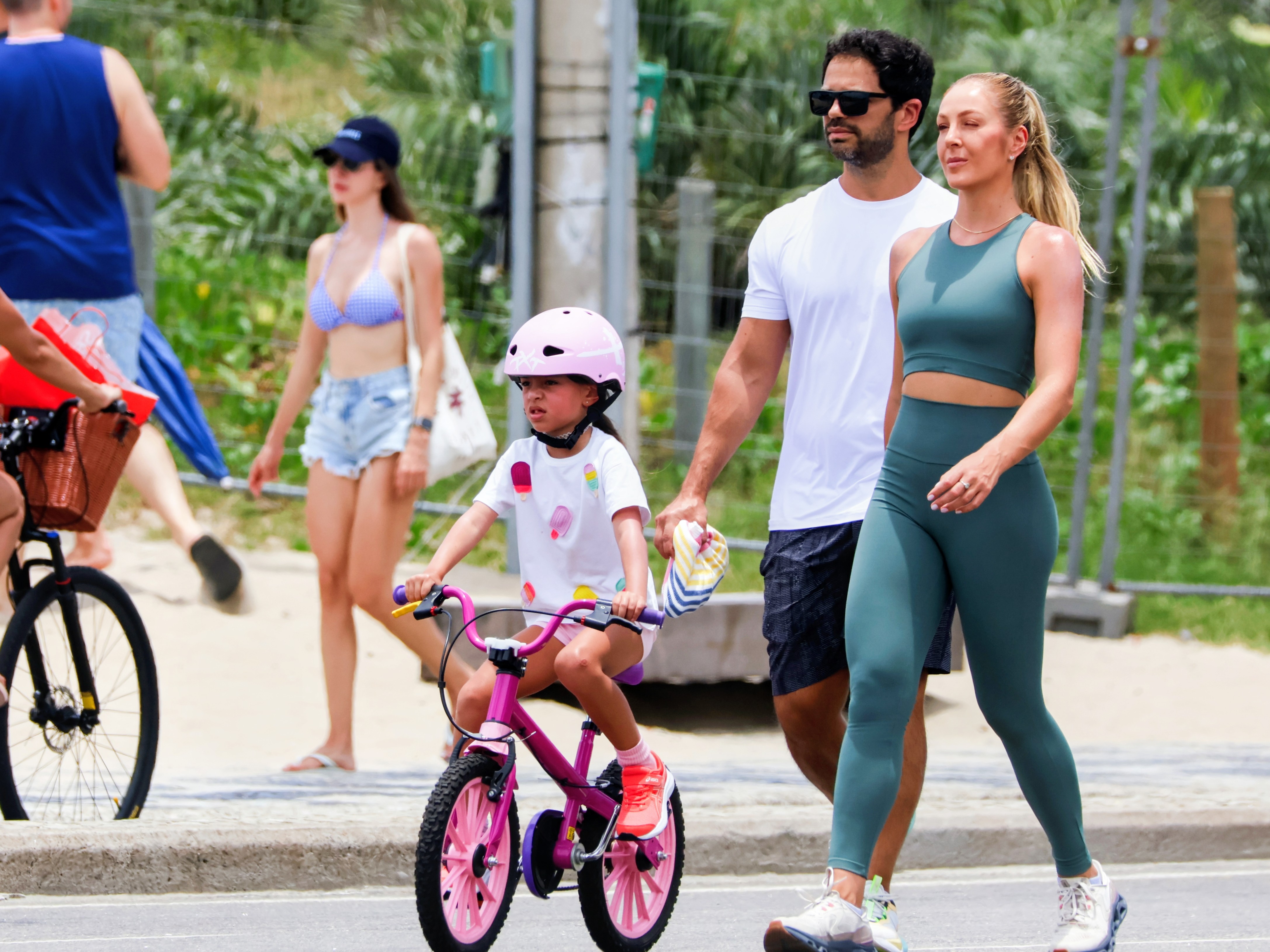 Duda Nagle caminha com a filha , Zoe , e a namorada , Mariane Heller pela orla do Rio