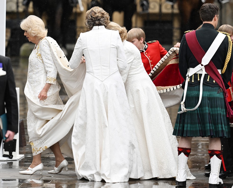 Rainha Camilla recebe ajuda para não sujar vestido branco — Foto: Getty Images