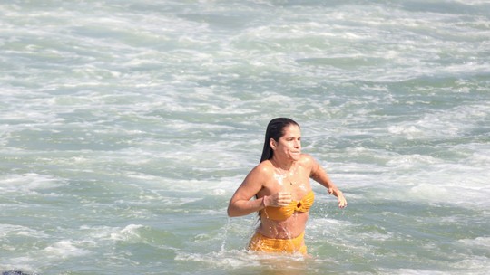 De biquíni amarelo, Ingrid Guimarães toma banho de mar em praia carioca