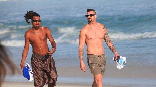 Ex-BBBs Luigi e Nizam curtem praia no Rio e posam com fãs