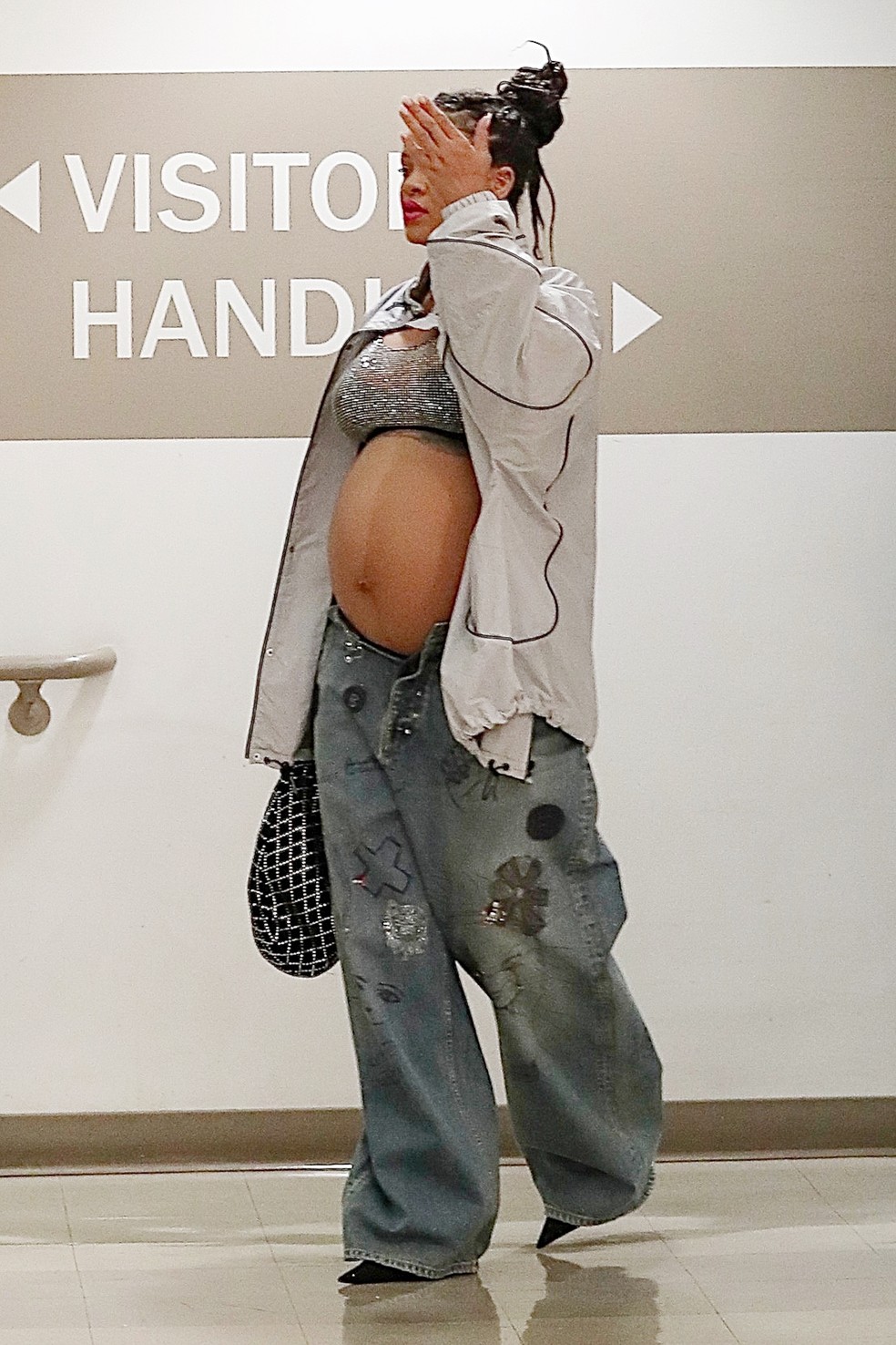 Grávida, Rihanna chama atenção com top brilhante e botão de calça aberto