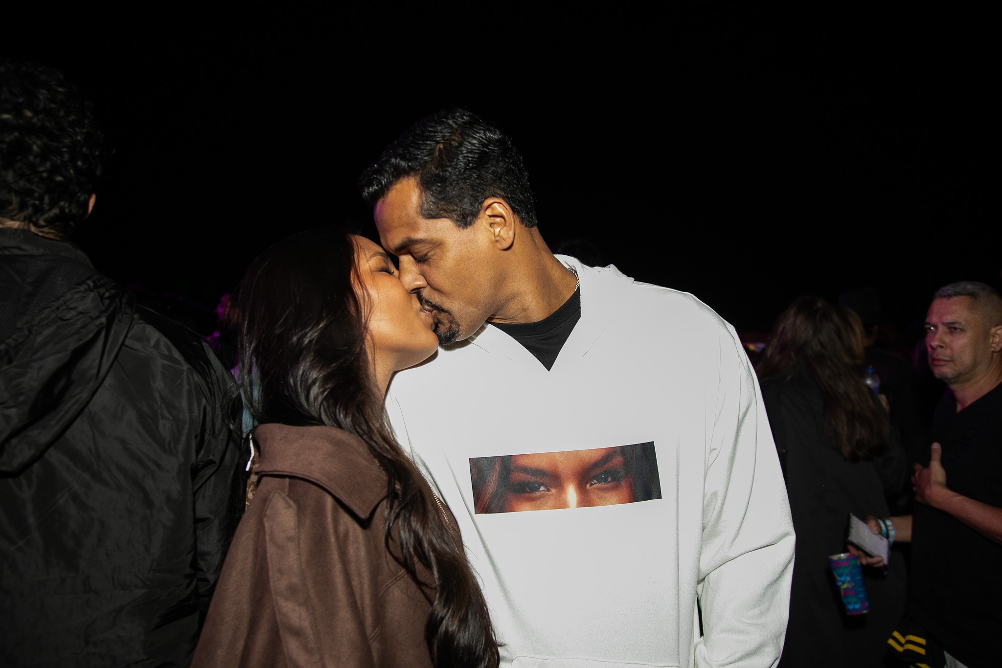 Marcello Melo Jr. usa moletom com olhos de Mell Muzzillo estampados e casal troca beijos no Rio