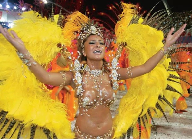 2006: Com a volta da Gaviões da Fiel ao Grupo Especial das Escolas de Samba de São Paulo, Sabrina desfilou exuberante, com um costeiro de penas amarelas. O bustiê - com detalhes em prata e dourado - ficou um pouquinho apertado, fazendo com que a apresentadora "pagasse peitinho" no desfile. Mesmo com o imprevisto, ela não perdeu o ânimo para sambar. — Foto: Agnews