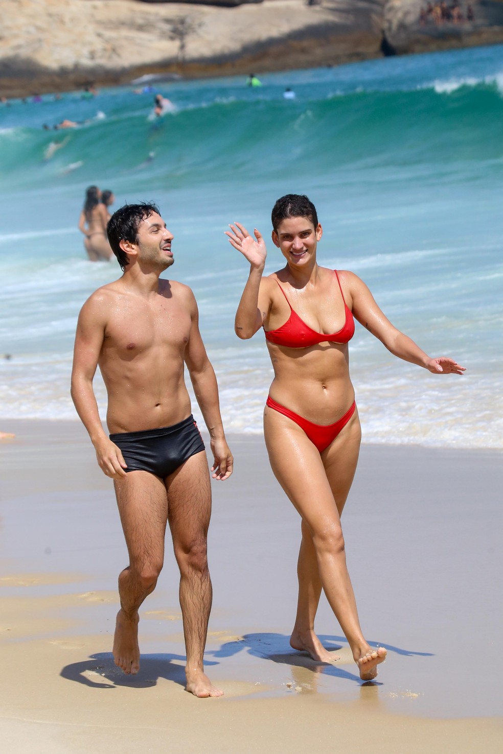Laura Fernandez aproveita praia com amigo no Rio e acena para fotógrafo — Foto: JC PEREIRA/ AGNEWS