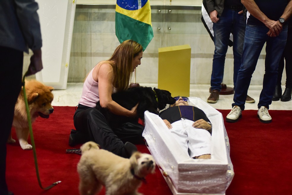 Com caixão no chão, viúva e cachorros de Nahim se despedem do cantor — Foto: Leo Franco/AgNews