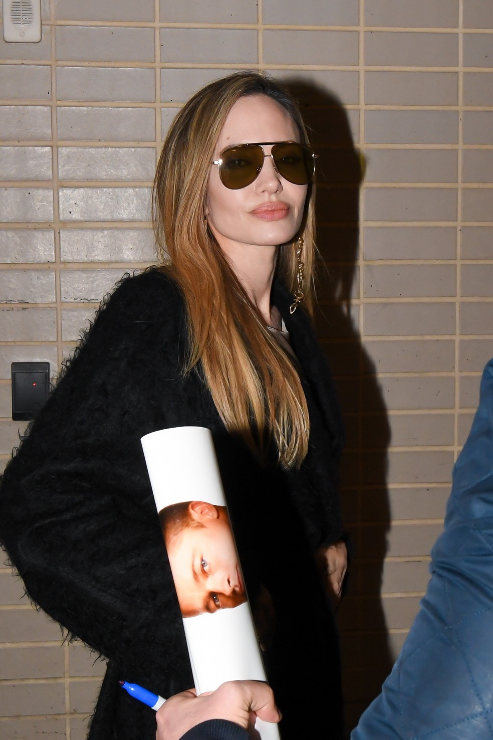 Angelina Jolie autografa pôster de fã que tem imagem do ex-marido Brad Pitt — Foto: Getty Images
