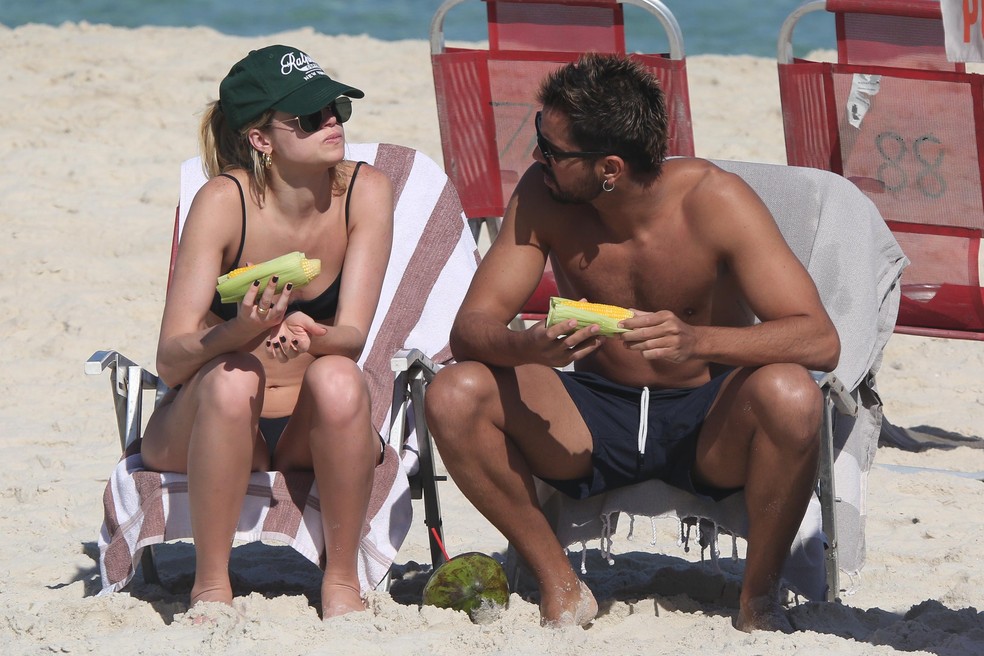 Agatha Moreira e Rodrigo Simas comem milho verde em praia do Rio — Foto: AgNews