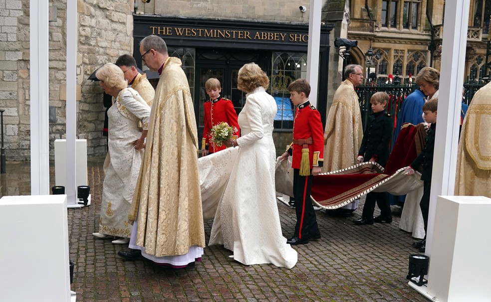 Rainha Camilla recebe ajuda para não sujar vestido branco — Foto: Getty Images