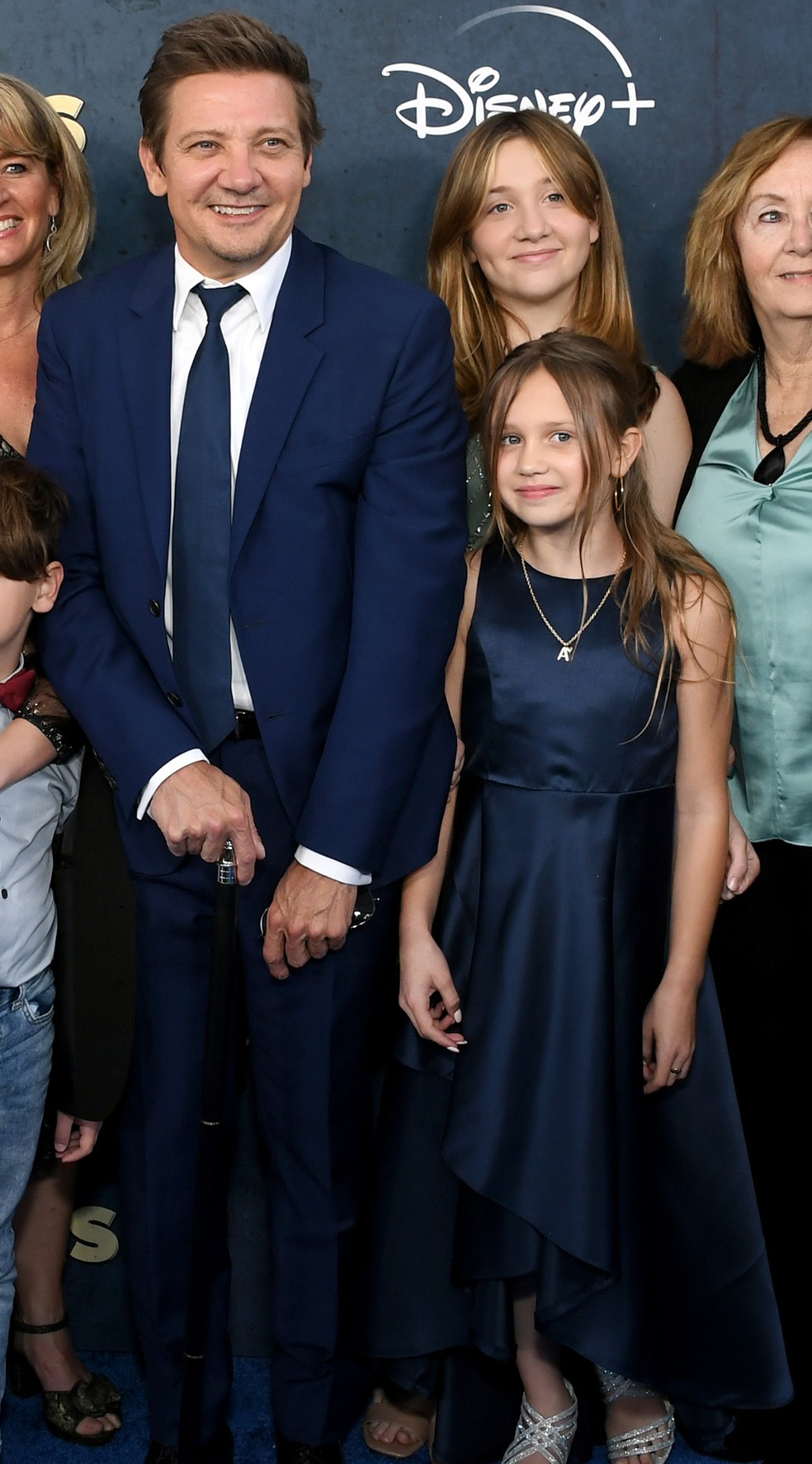 Jeremy Renner e a filha, Ava (de vestido azul ao seu lado) — Foto: Getty Images
